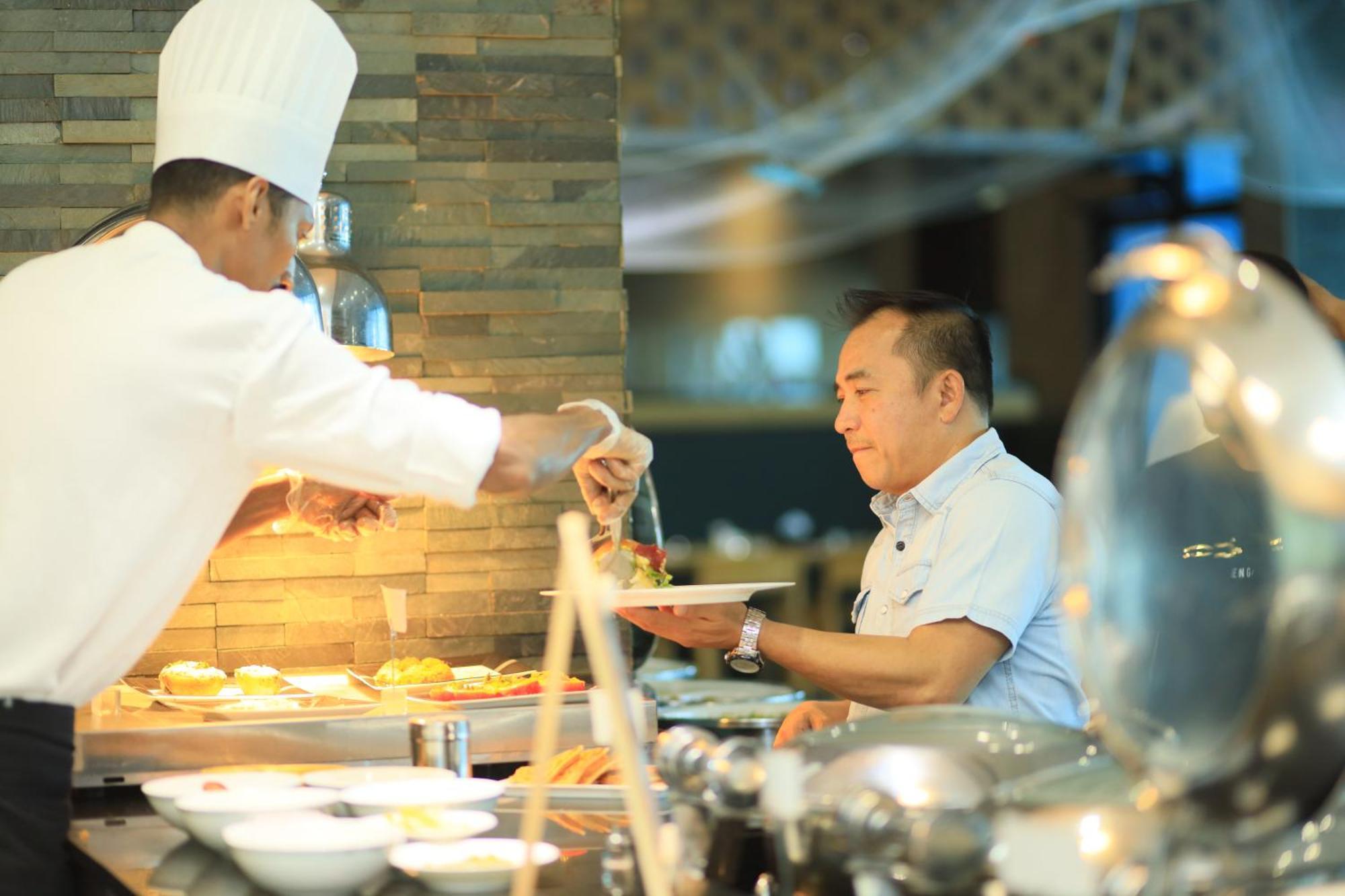 Ramee Grand Hotel And Spa Manama Eksteriør billede A chef serving food at a buffet